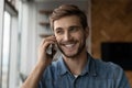 Happy positive millennial man making call, talking on cellphone