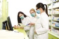 Happy positive pharmacists with surgical masks