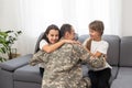 happy positive smiling soldier man in camouflage sitting with his daughter on sofa, looking how his kid grown when he Royalty Free Stock Photo