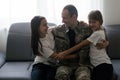 happy positive smiling soldier man in camouflage sitting with his daughter on sofa, looking how his kid grown when he Royalty Free Stock Photo