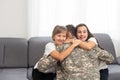 happy positive smiling soldier man in camouflage sitting with his daughter on sofa, looking how his kid grown when he Royalty Free Stock Photo