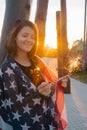 positive smiling young woman with sparklers and USA flag portrait at the sunset in park Royalty Free Stock Photo