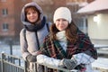 Happy positive two stylish girls standing on street in city. Closeup portrait funny joyful attractive young women dressing winter