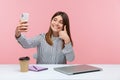 Happy positive woman blogger showing thumbs up like gesture recording video for her subscribers, giving recommendations sitting at Royalty Free Stock Photo