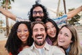 Happy and positive young adult friends having fun taking a selfie with a cellphone. Smiling multiracial people laughing Royalty Free Stock Photo