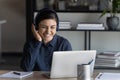 Happy positive young indian businesswoman listening to music in headphones.