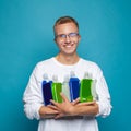 Happy positive young man holding recyclable plastic bottle on blue background Royalty Free Stock Photo