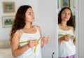 Happy young woman measuring breasts with measuring tape Royalty Free Stock Photo