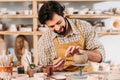 happy potter in apron decorating ceramic bowl Royalty Free Stock Photo