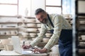 Happy potter using laptop and smiling at camera Royalty Free Stock Photo