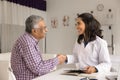 Happy practitioner woman and senior Indian patient man shaking hands