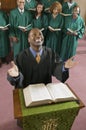 Happy preacher with Bible at church altar looking up high angle view