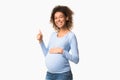 Happy pregnancy. Positive black pregnant woman gesturing thumb up