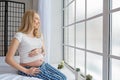 Happy pregnancy sitting on sofa at home in bedroom Royalty Free Stock Photo
