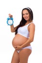 Happy pregnancy. Smiling pregnant woman holding alarm clock. Royalty Free Stock Photo