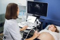 Happy pregnancy time, ultrasound concept. Pretty pregnant woman doing ultrasound scan in the prenatal clinic, worried Royalty Free Stock Photo