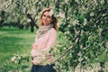 Happy pregnant blonde beautiful woman walking outdoor in spring park or garden Royalty Free Stock Photo