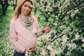 Happy pregnant blonde beautiful woman walking outdoor in spring park or garden Royalty Free Stock Photo