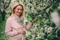 Happy pregnant blonde beautiful woman walking outdoor in spring park or garden Royalty Free Stock Photo