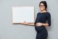 Happy pregnant business lady holding copyspace blank.