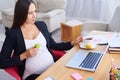 Happy pregnant businesswoman having breakfast at office Royalty Free Stock Photo