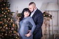 Happy pregnant couple hugging in room. Happy bride and groom are waiting for a baby Royalty Free Stock Photo