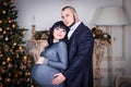 Loving family, husband and wife in hall with Christmas tree and fireplace Royalty Free Stock Photo