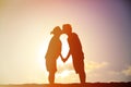 Happy pregnant couple kissing at sunset beach Royalty Free Stock Photo