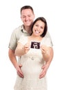 Happy pregnant couple showing ultrasound picture