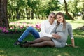 Happy pregnant woman, family couple in the park, green floral background. In anticipation of a miracle, a child. Family life, Royalty Free Stock Photo