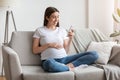 Happy pregnant millennial woman using smartphone at home, browsing pregnancy app Royalty Free Stock Photo