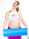 Happy pregnant woma with exercise mat Royalty Free Stock Photo