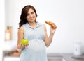 Happy pregnant woman with apple and croissant Royalty Free Stock Photo