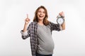 happy pregnant woman with clock in hand pointing up