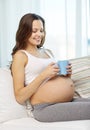 Happy pregnant woman with cup drinking tea at home Royalty Free Stock Photo