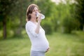 Happy pregnant woman drinking natural water in park Royalty Free Stock Photo