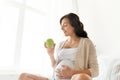 Happy pregnant woman eating green apple at home Royalty Free Stock Photo