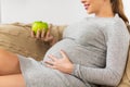 Happy pregnant woman eating green apple at home Royalty Free Stock Photo