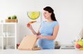 Happy pregnant woman eating pizza at home kitchen Royalty Free Stock Photo