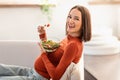 Happy Pregnant Woman Eating Salad Sitting On Couch At Home Royalty Free Stock Photo