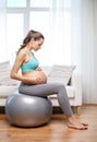 Happy pregnant woman exercising on fitball at home Royalty Free Stock Photo