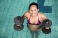 Happy pregnant woman exercising in the pool with weights Royalty Free Stock Photo