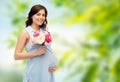 Happy pregnant woman with flowers touching belly Royalty Free Stock Photo