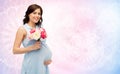 Happy pregnant woman with flowers touching belly Royalty Free Stock Photo