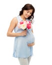 Happy pregnant woman with flowers touching belly Royalty Free Stock Photo