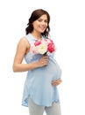 Happy pregnant woman with flowers touching belly Royalty Free Stock Photo