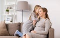 Happy pregnant woman and girl gossiping at home Royalty Free Stock Photo