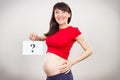Happy pregnant woman holding card with question mark. Expecting birth of boy or girl. Extending family. Motherhood Royalty Free Stock Photo