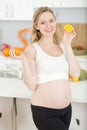happy pregnant woman holding orange fruit Royalty Free Stock Photo