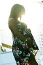 Happy pregnant woman hugging her stomach on the background of flowers,outdoor Royalty Free Stock Photo